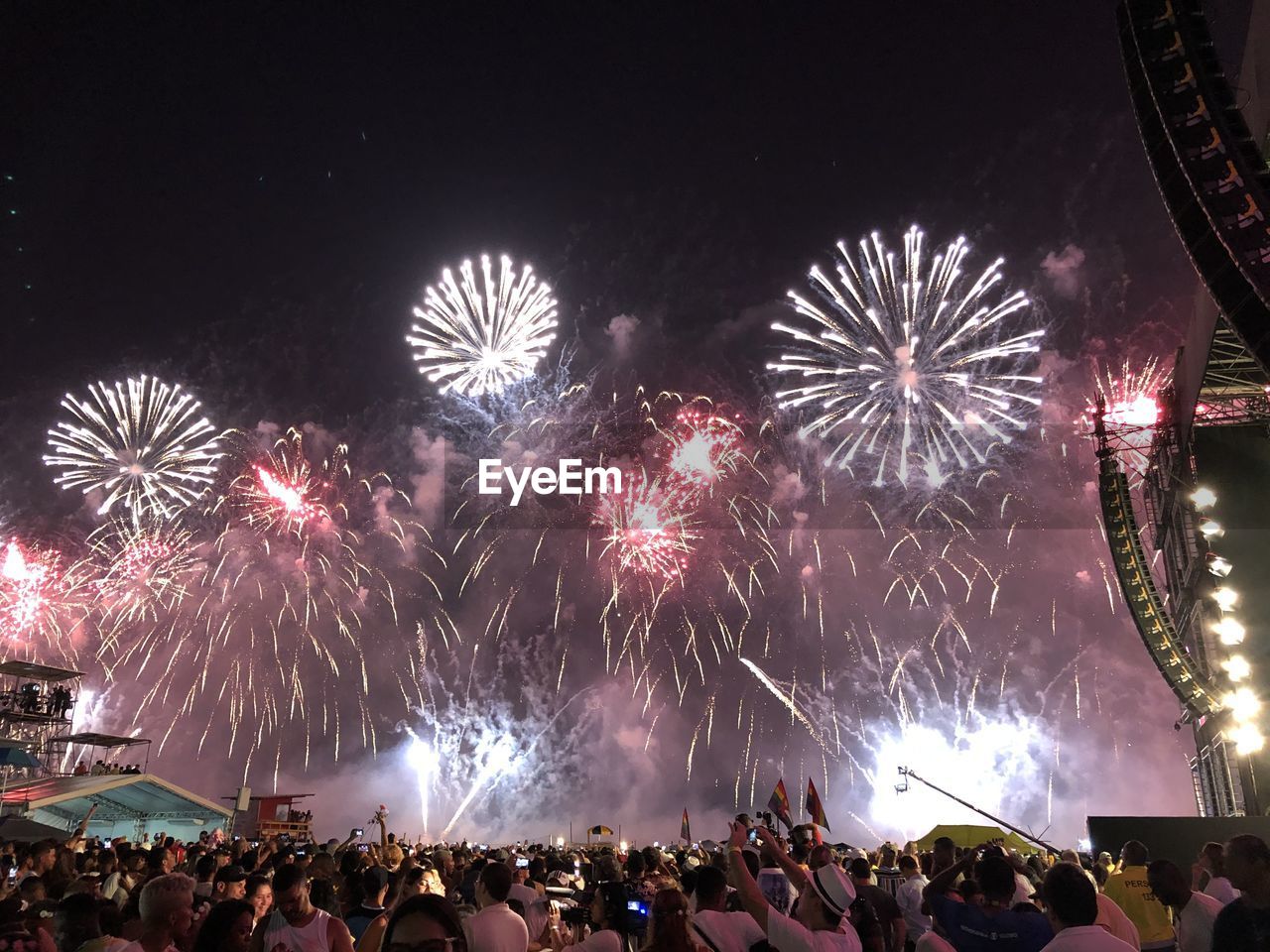 People watching at firework display during night