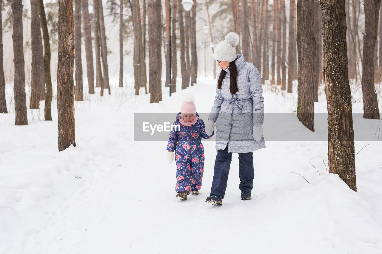 FULL LENGTH OF WOMAN IN SNOW COVERED TREES