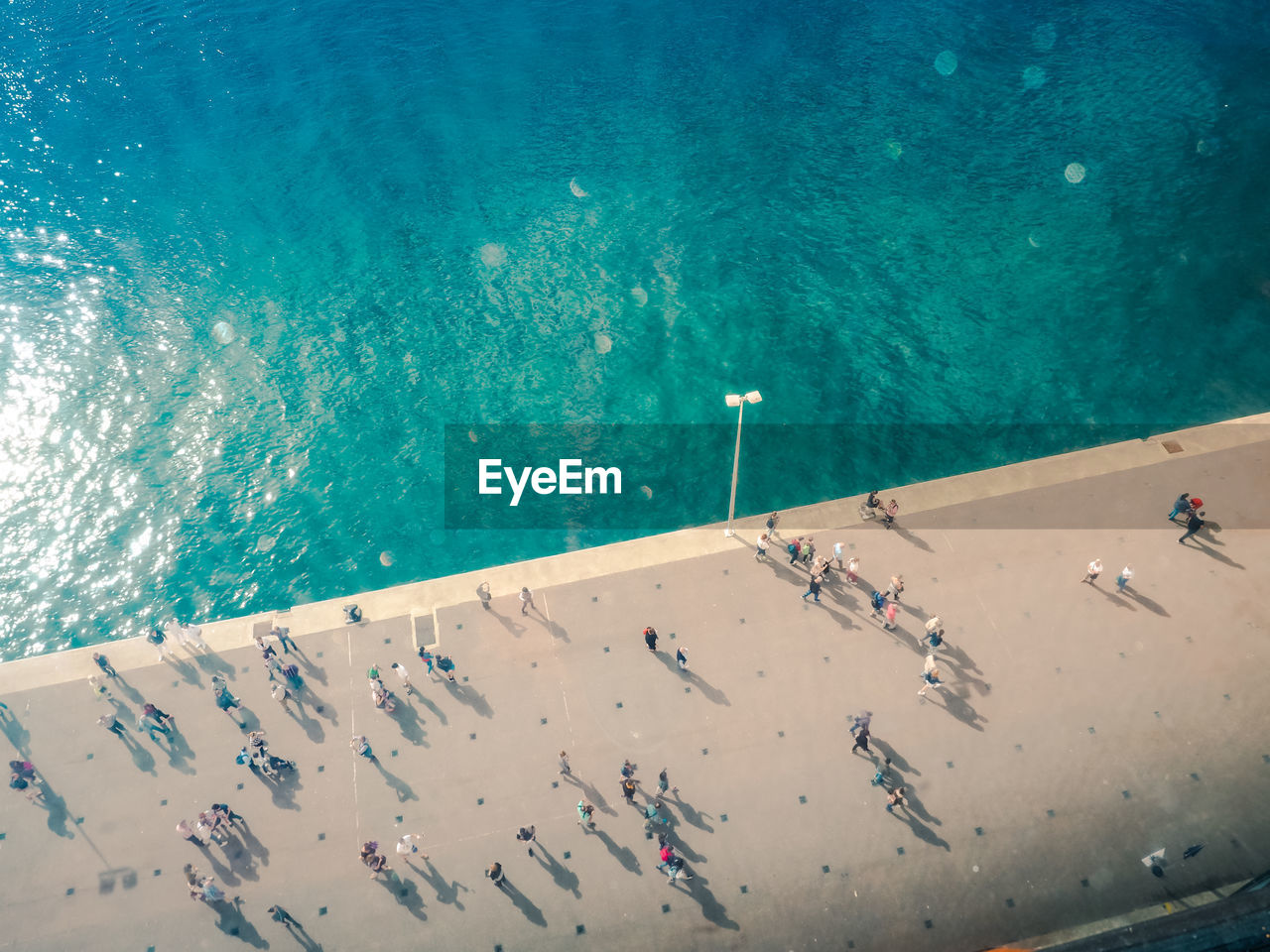 High angle view of people walking on promenade by sea