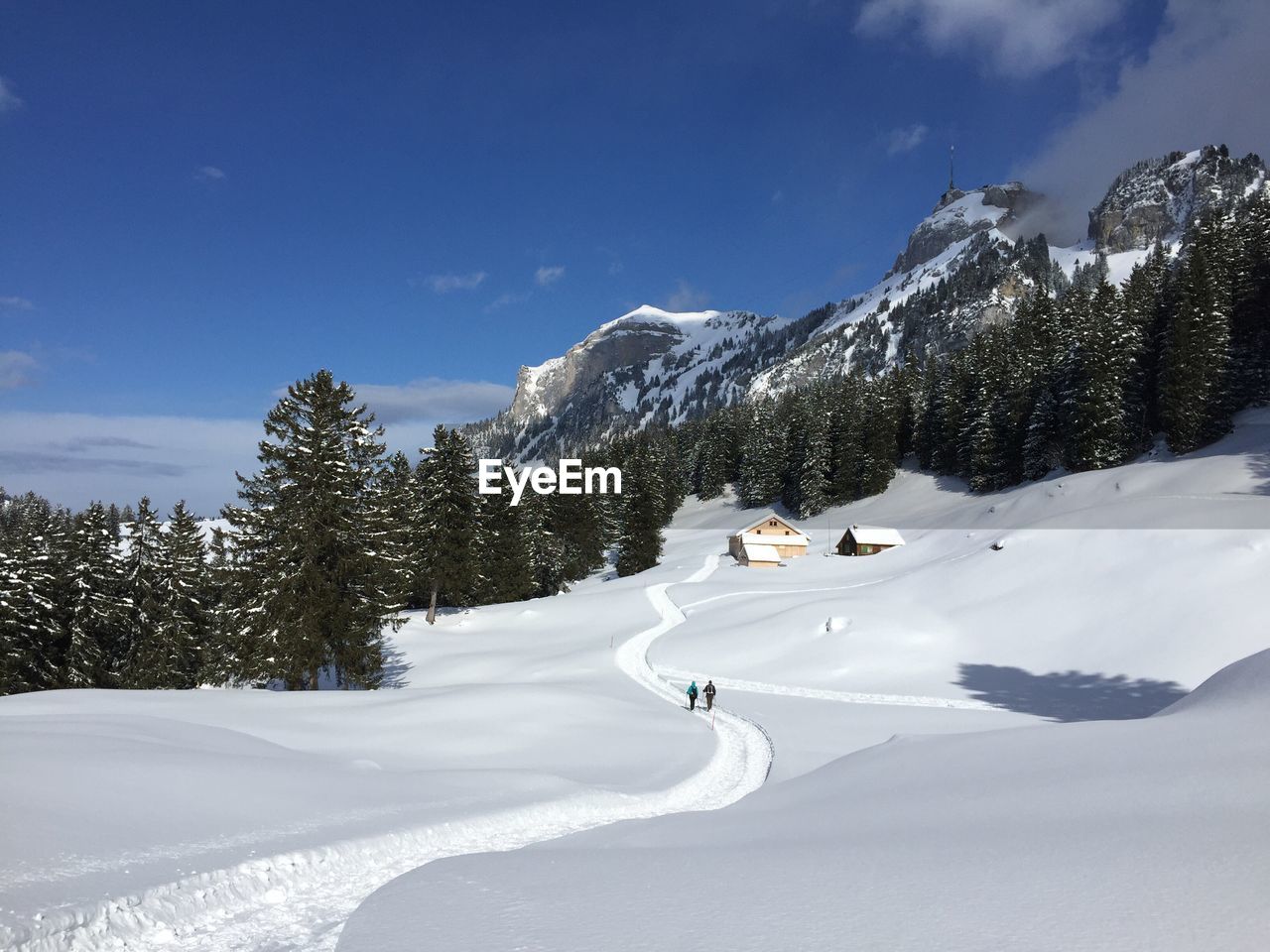 Scenic view of snow covered mountains against blue sky