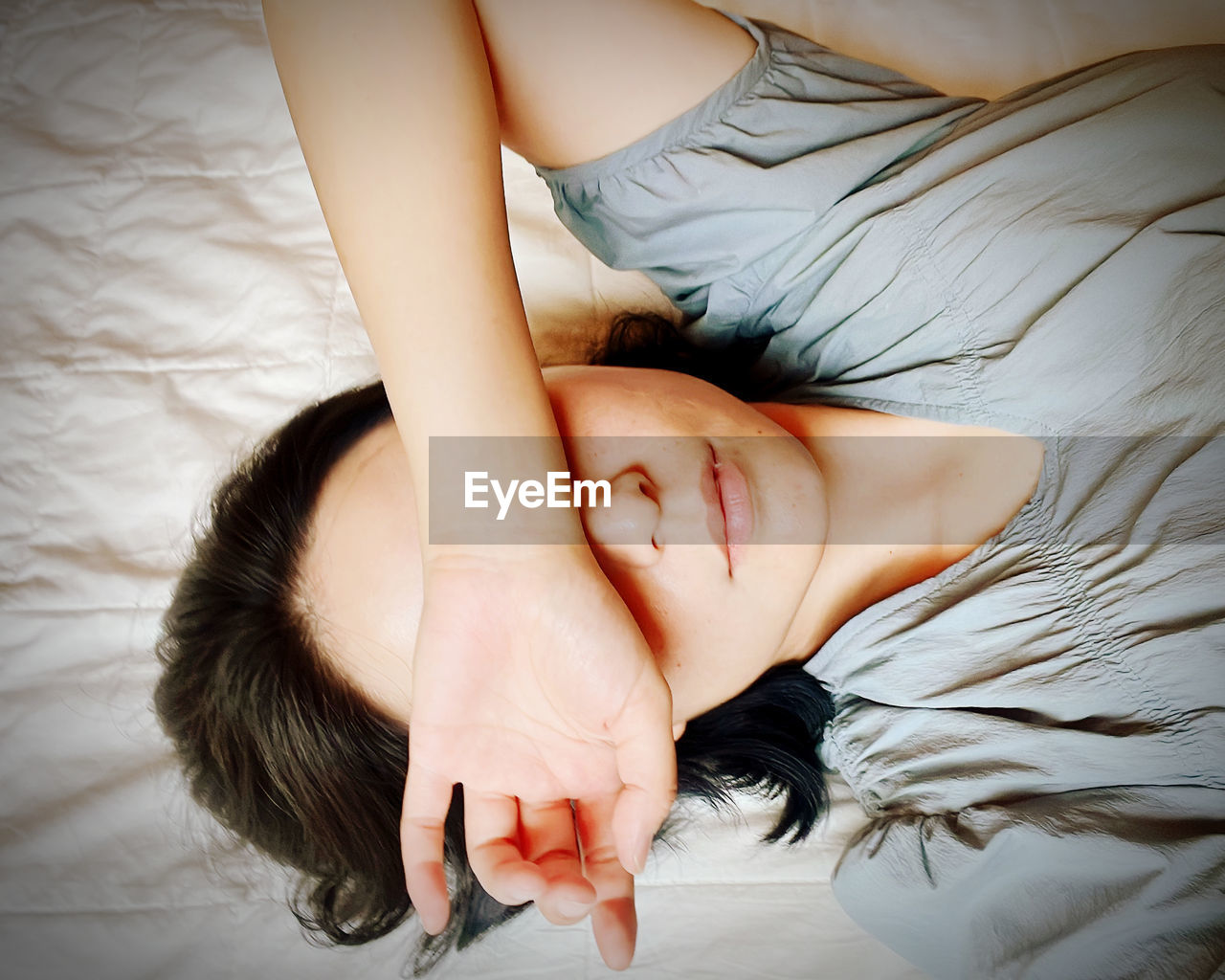 Image of woman lying on bed looking tired