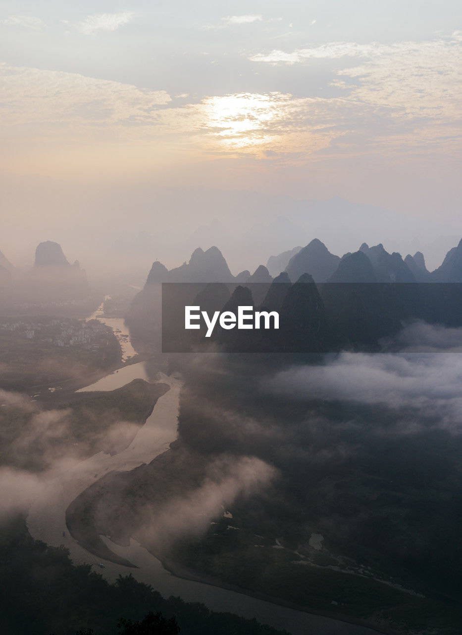 Mountain peaks under cloudy sky at sunrise, guilin, china