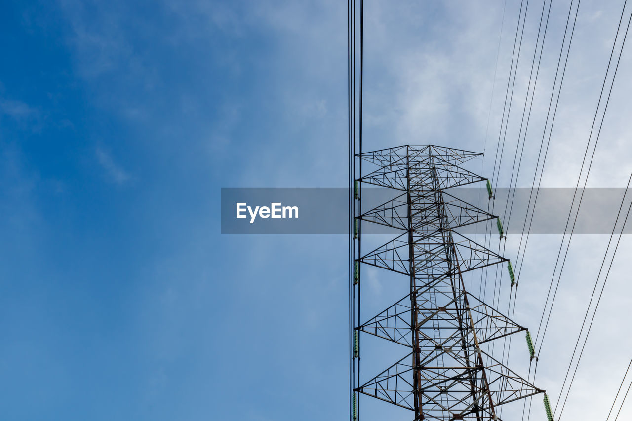 DIRECTLY BELOW SHOT OF ELECTRICITY PYLON AGAINST SKY