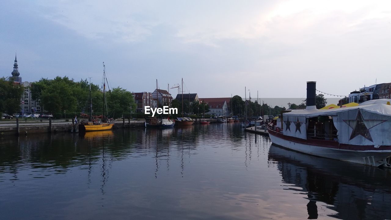 Boats moored at river against sky