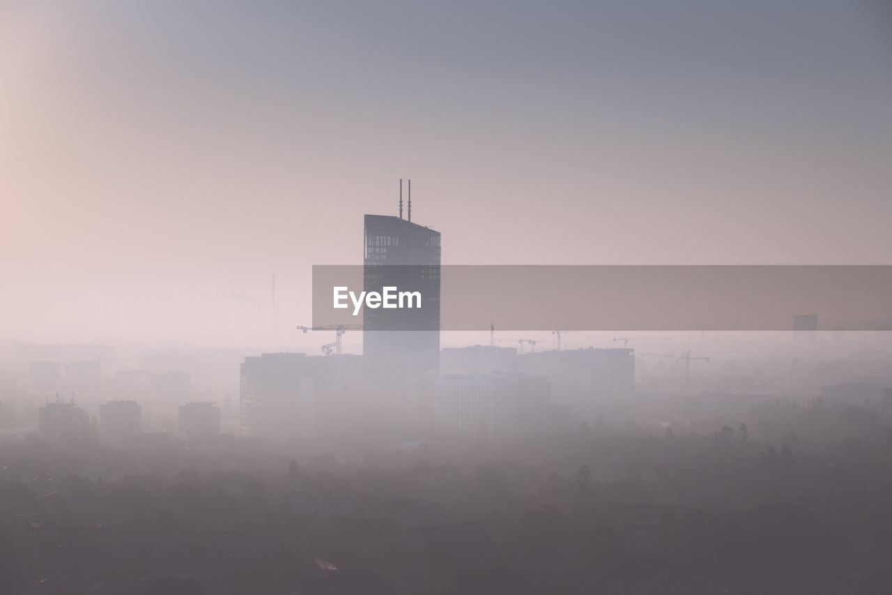 Buildings in city against sky during sunset