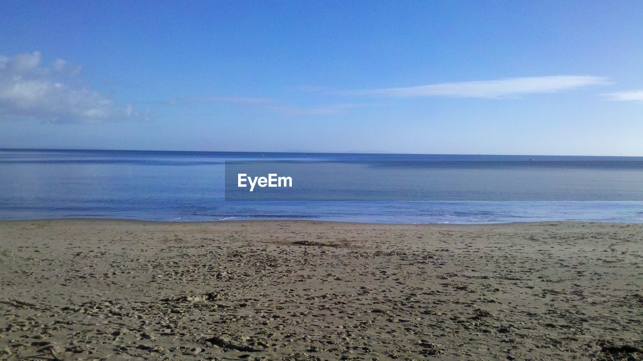 Scenic view of beach against blue sky