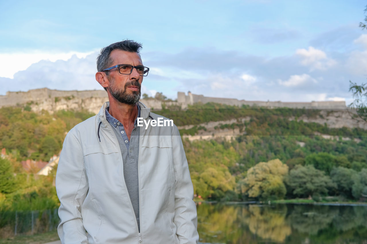 Portrait of man standing against sky