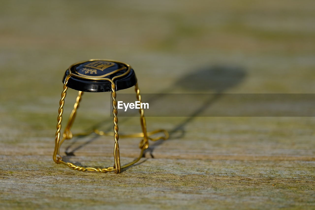 yellow, macro photography, no people, close-up, selective focus, focus on foreground, single object, metal, table, green, wood, day