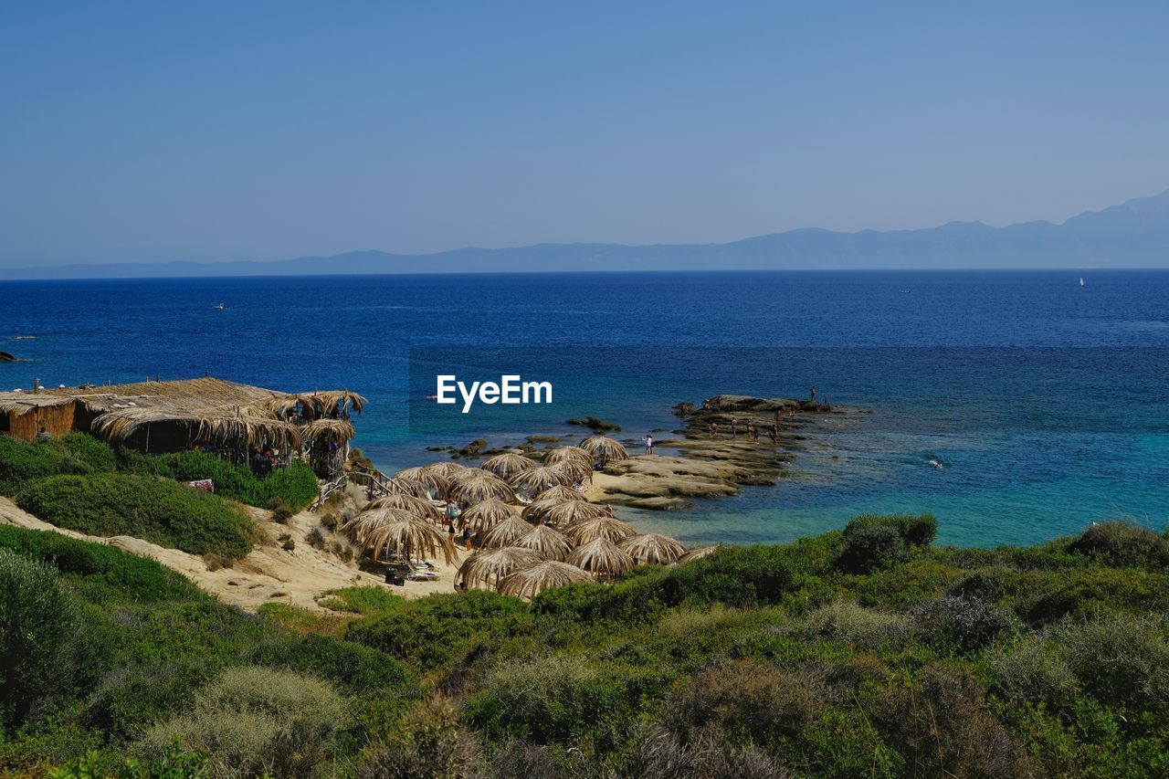 water, sea, sky, land, scenics - nature, coast, beauty in nature, ocean, nature, shore, beach, cliff, body of water, tranquility, rock, vacation, tranquil scene, no people, clear sky, cove, travel destinations, plant, horizon, blue, travel, landscape, environment, terrain, bay, day, horizon over water, coastline, tourism, mountain, outdoors, non-urban scene, idyllic, islet, architecture, grass, promontory, sunny