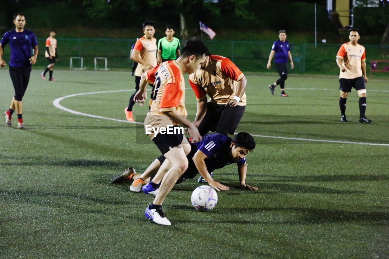 sports, group of people, full length, athlete, sports clothing, team sport, grass, soccer, ball game, motion, men, group, adult, competition, soccer player, clothing, ball, sports equipment, medium group of people, player, soccer uniform, soccer field, sports uniform, young adult, playground, soccer ball, football player, activity, tournament, football, exercising, crowd, cooperation, teamwork, lifestyles, athleticism, outdoors, competition event, day, vitality, team, challenge, running