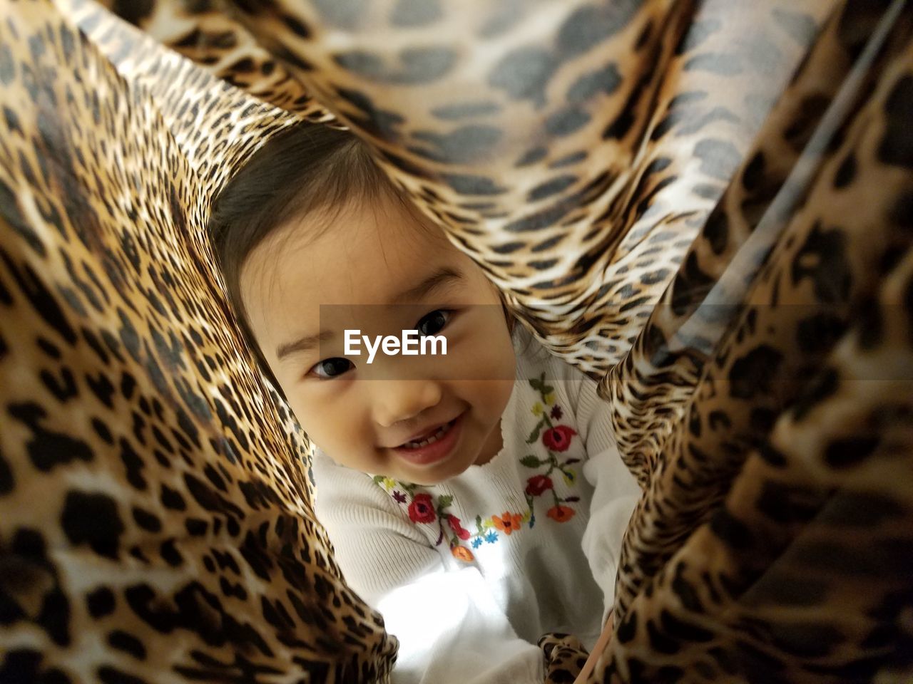 Close-up portrait of cute baby girl in blanket