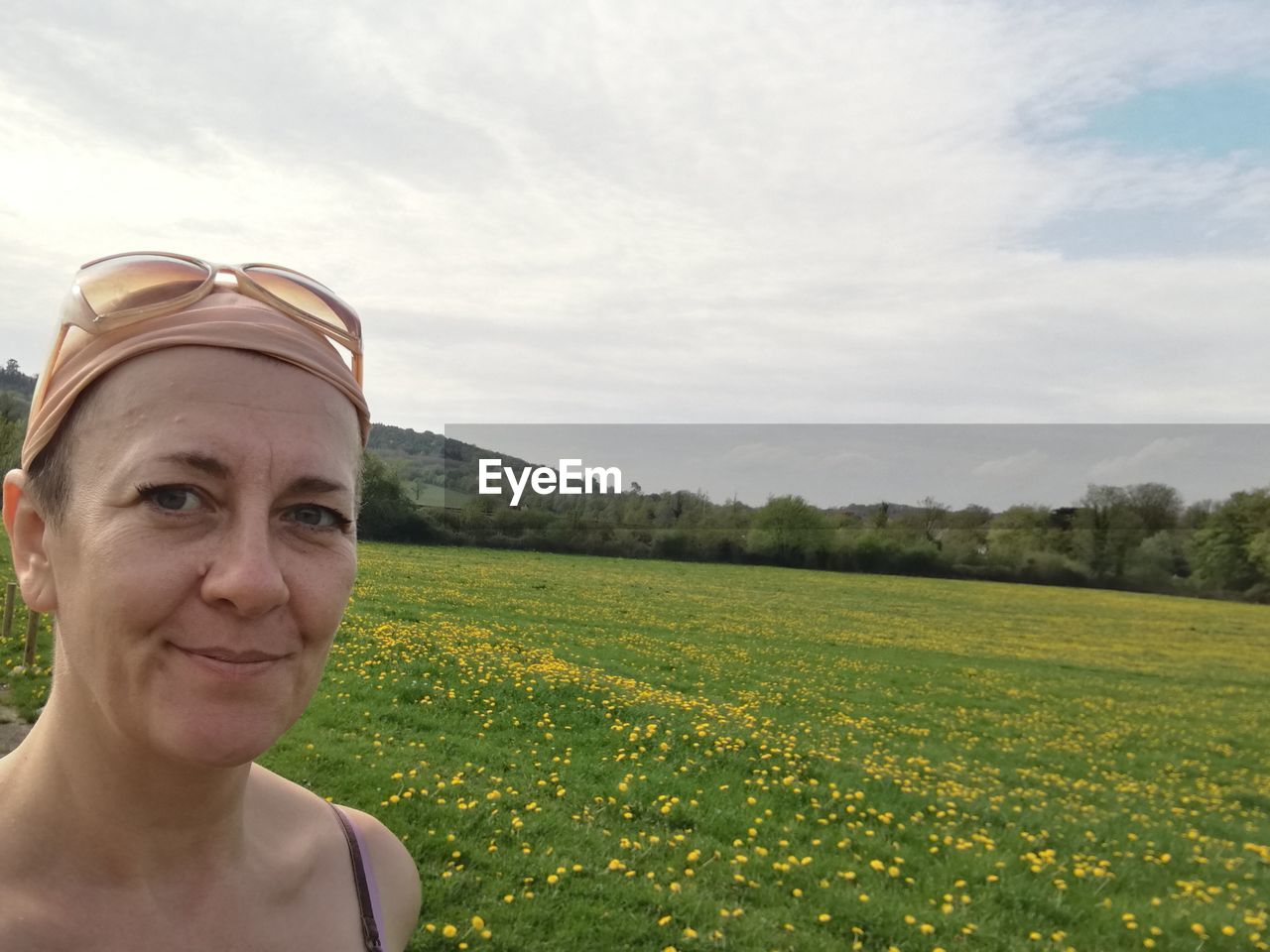 PORTRAIT OF SMILING WOMAN ON FIELD