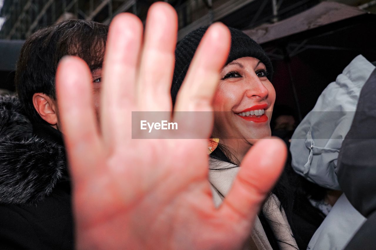 PORTRAIT OF SMILING WOMAN WITH HAND ON HANDS