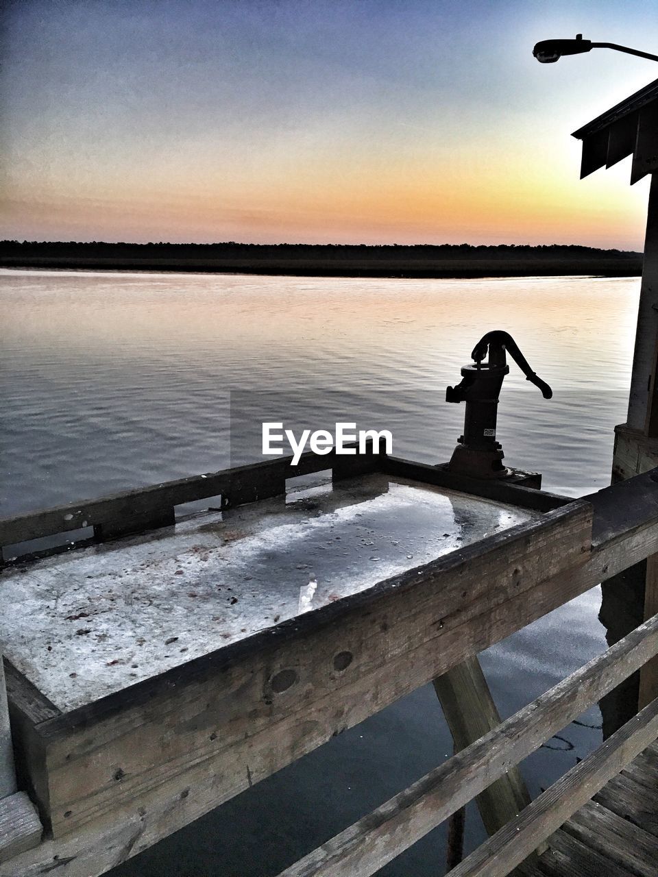 SILHOUETTE OF PIER ON CALM SEA