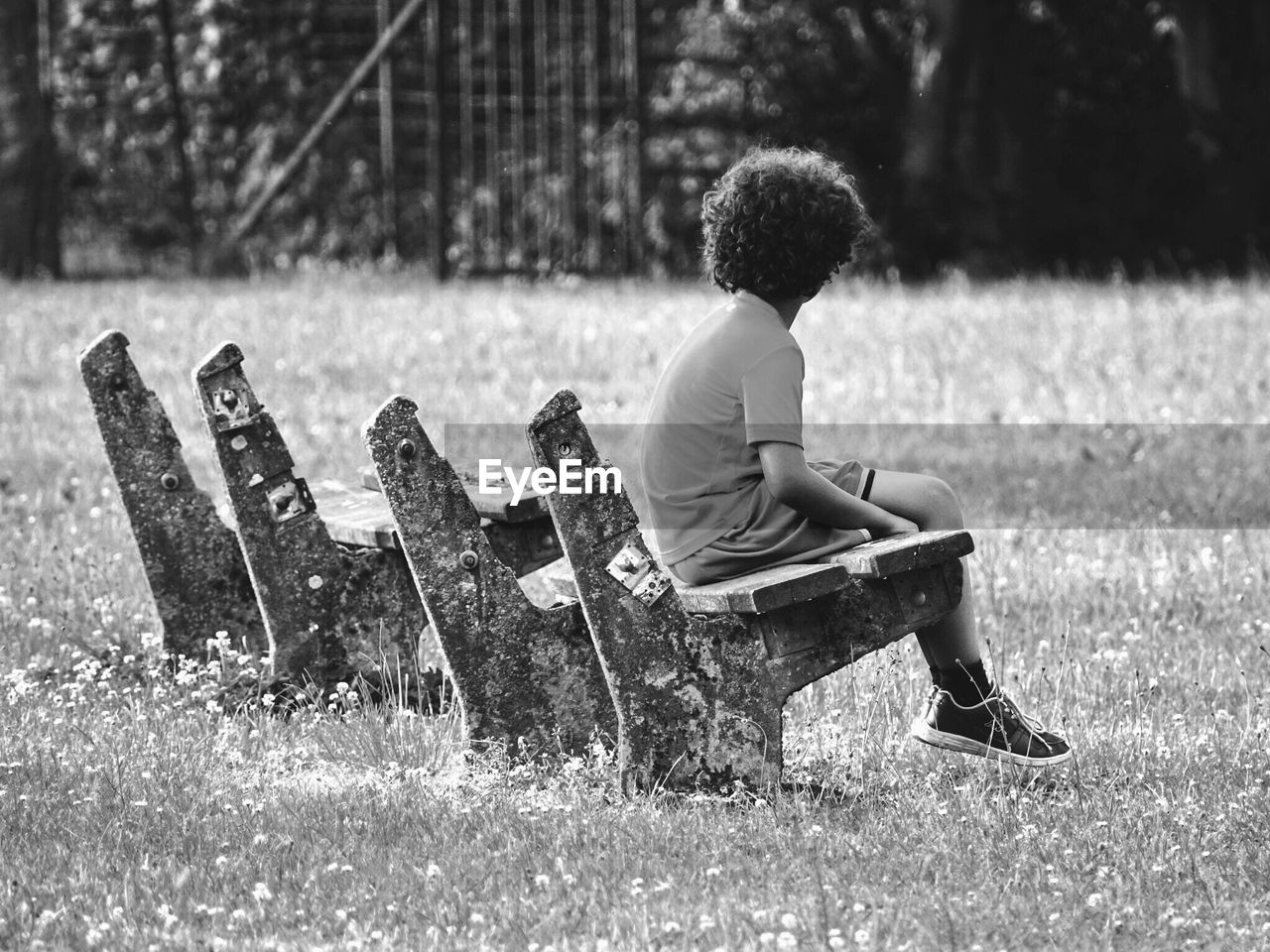 Full length of boy sitting on bench at park