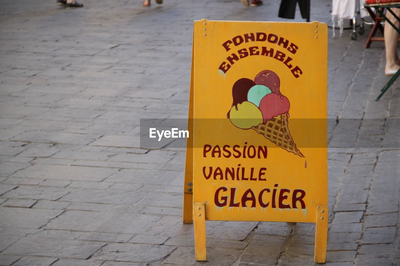 Sign board on footpath outside ice cream parlor