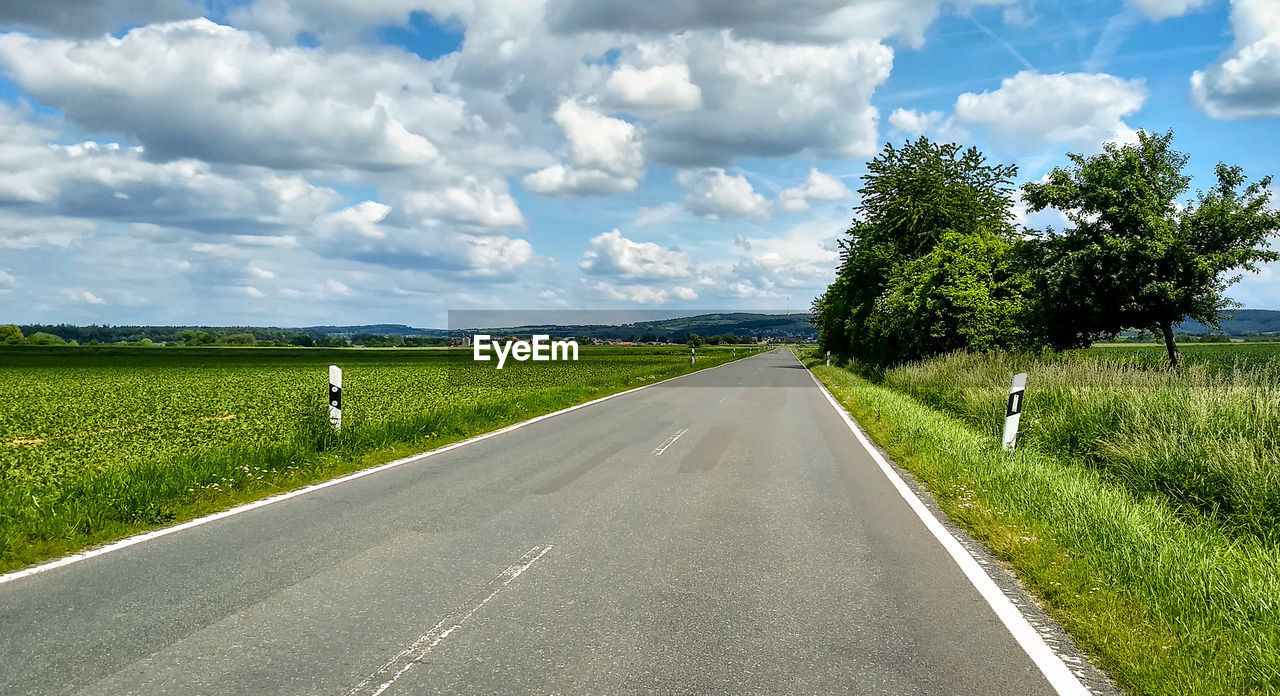 EMPTY ROAD ALONG LANDSCAPE AND AGAINST SKY