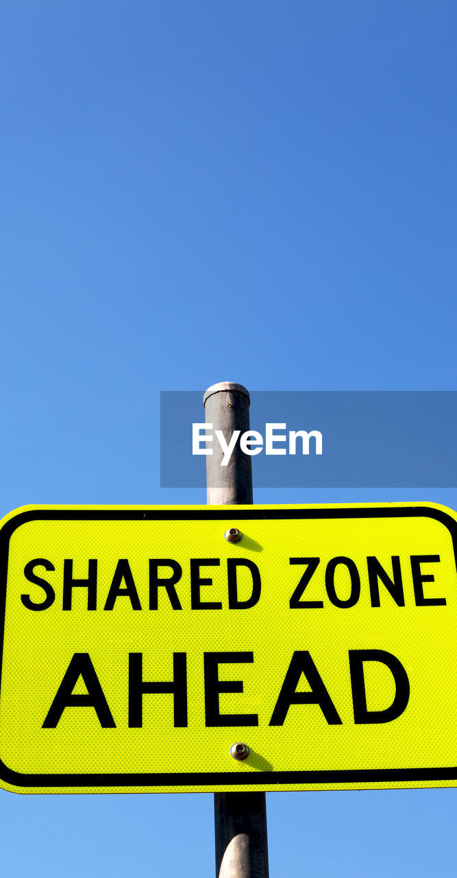 LOW ANGLE VIEW OF INFORMATION SIGN AGAINST CLEAR SKY