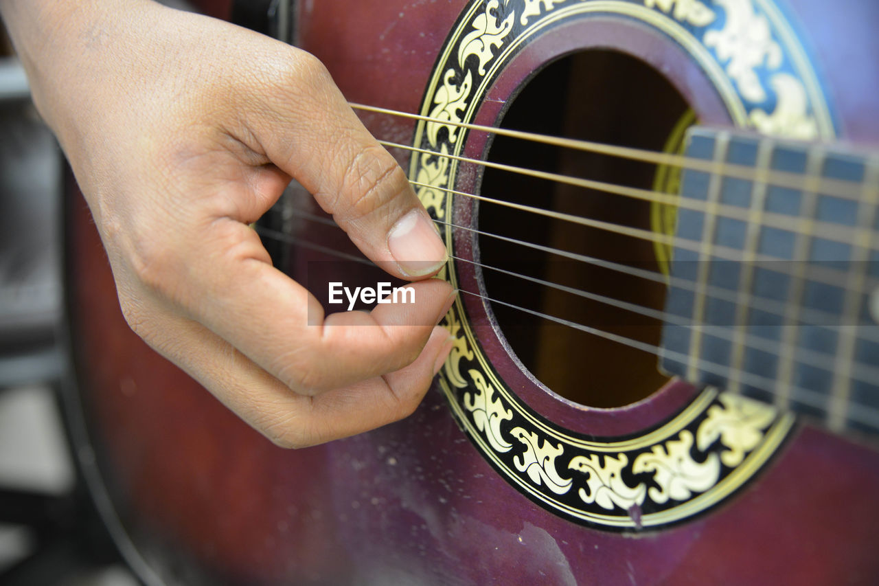 Cropped hand playing guitar