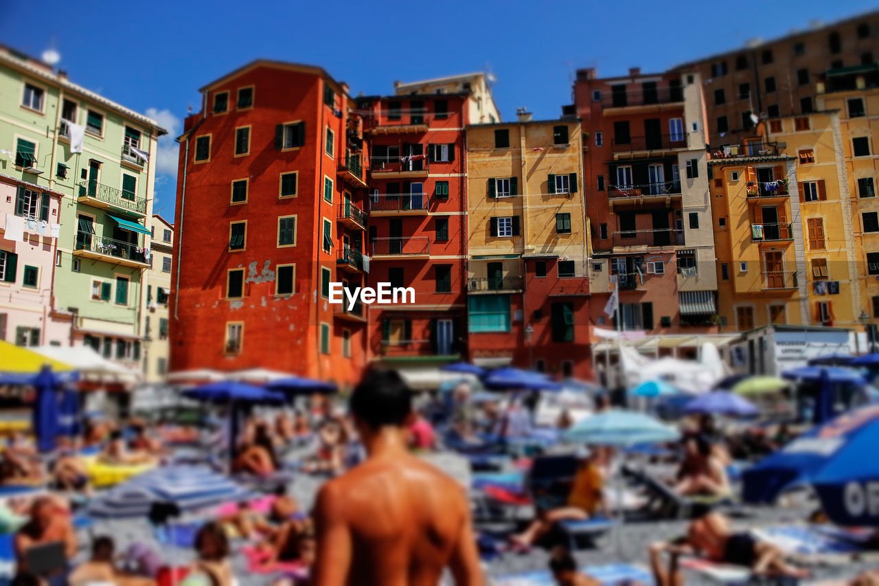 People at beach against buildings in camogli