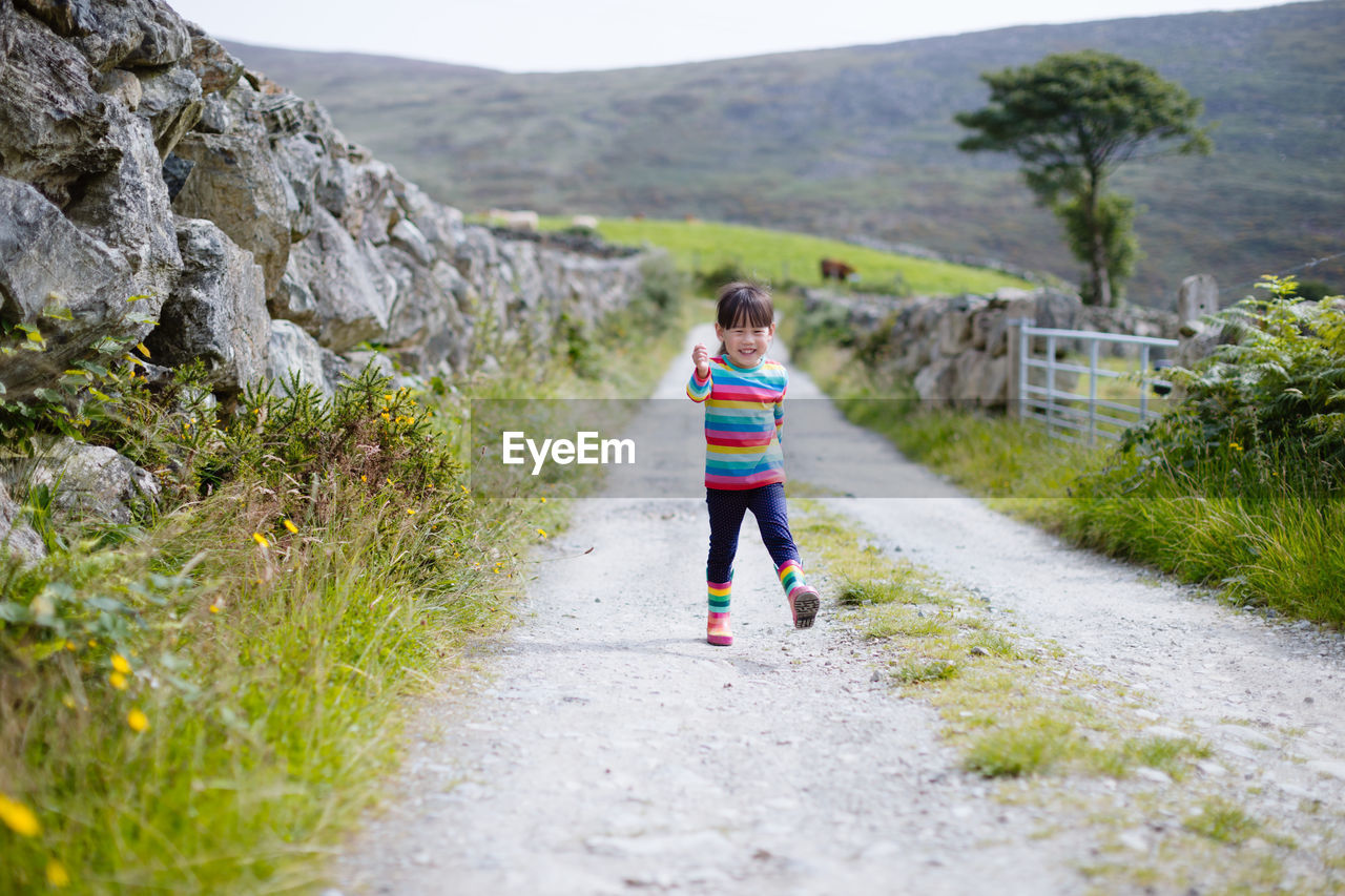 Young girl walking on summer countryside road