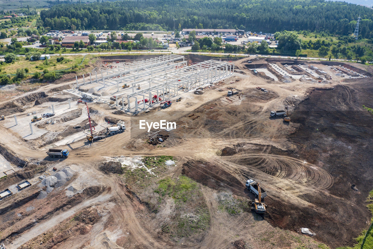 Aerial top view of huge construction site with many working heavy machines