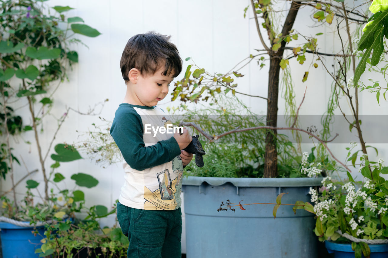 Boy playing with a stick in the garden