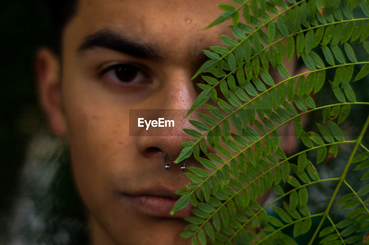 Close-up portrait of young man by plant