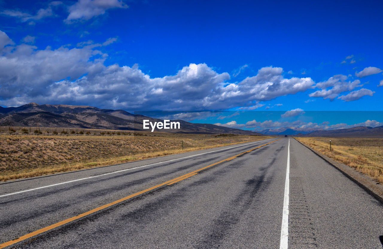 Empty road with mountains in background