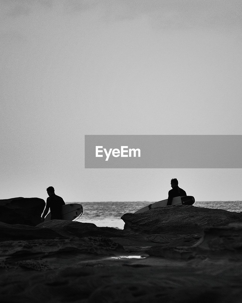 Two men at beach with surfboard