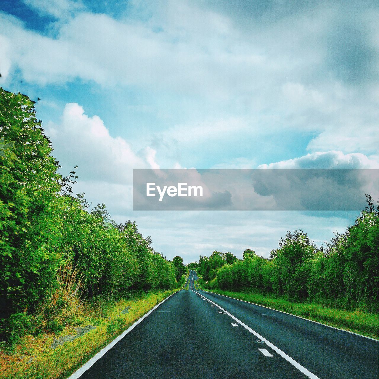 Scenic view of road against cloudy sky