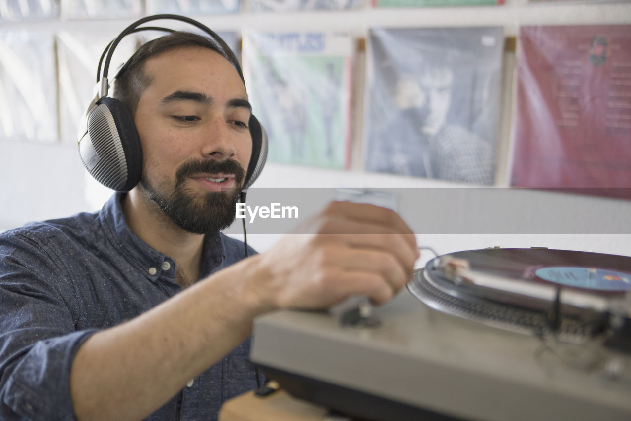 Young man listening to a record at a record store