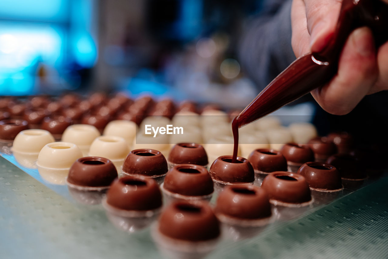 Hand filling pralines with chocolate