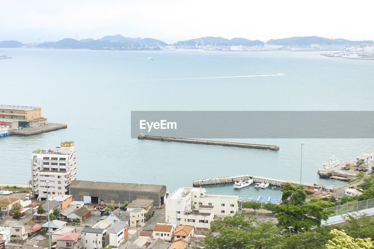 High angle view of city by sea against sky