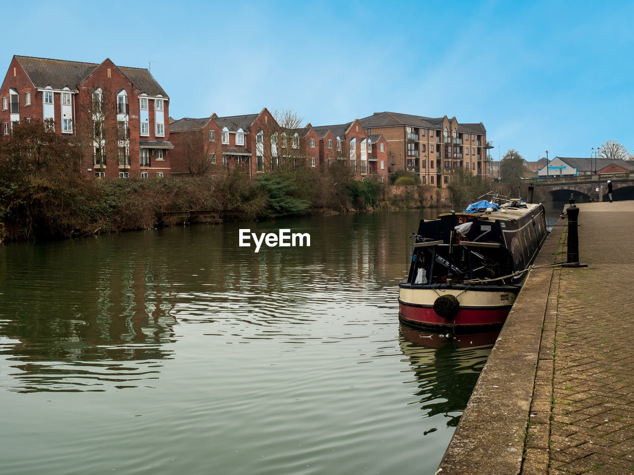 BUILDINGS BY RIVER AGAINST SKY