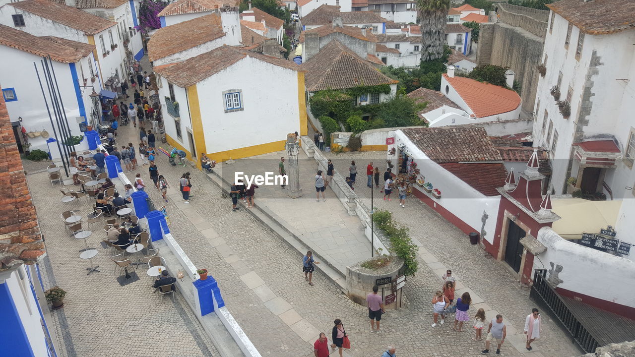 HIGH ANGLE VIEW OF PEOPLE ON STREET BY BUILDINGS