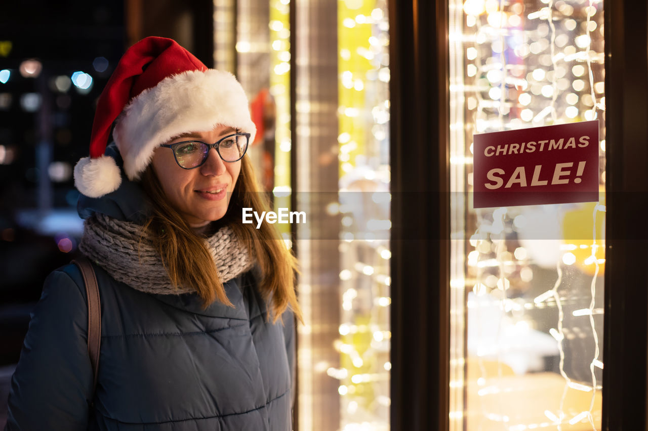 Smiling woman standing outside store during winter