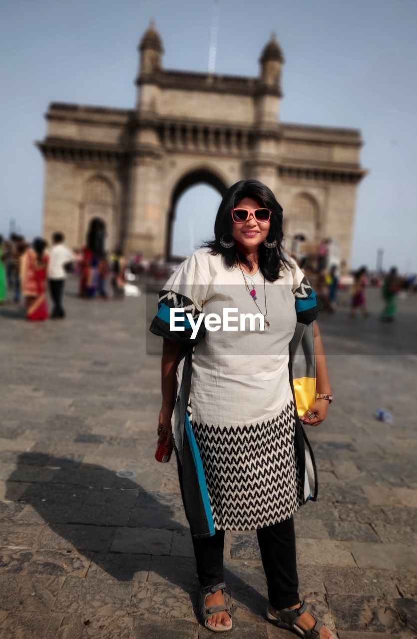 Smiling mid adult woman standing against gateway of india