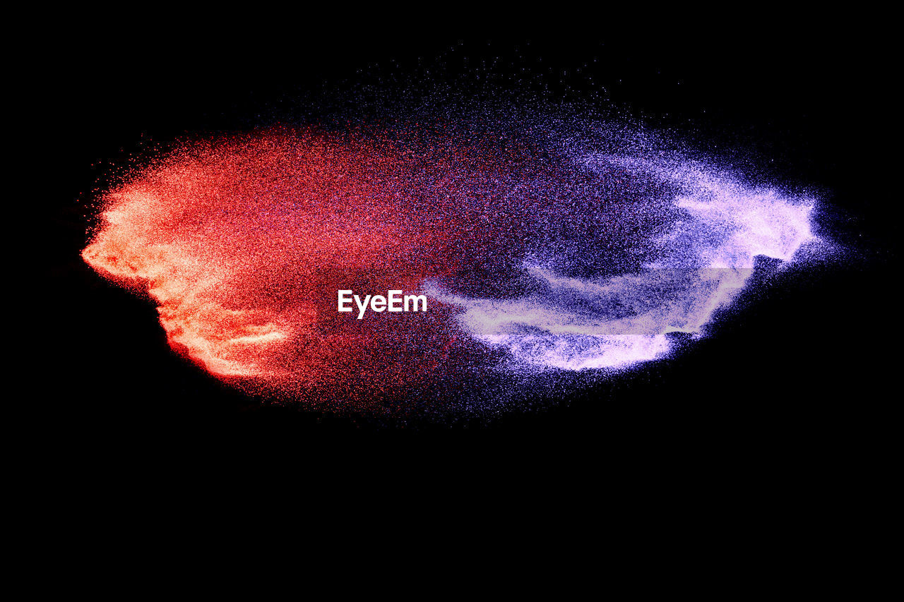 Defocused image of multi colored powder paints against black background