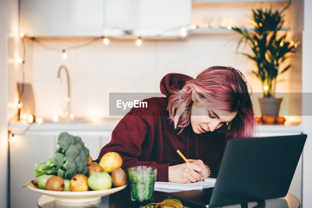 young woman using laptop while sitting at home