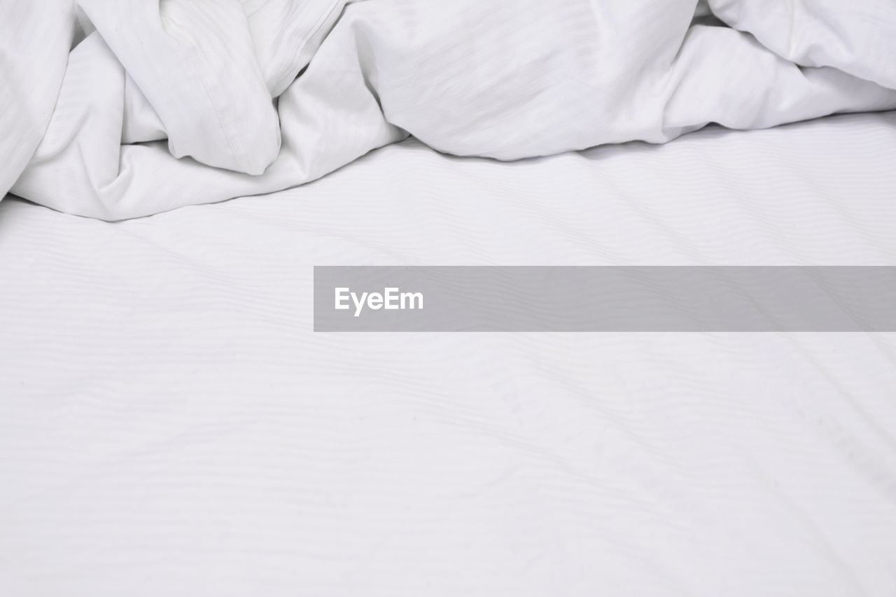 HIGH ANGLE VIEW OF WHITE BED ON BLANKET