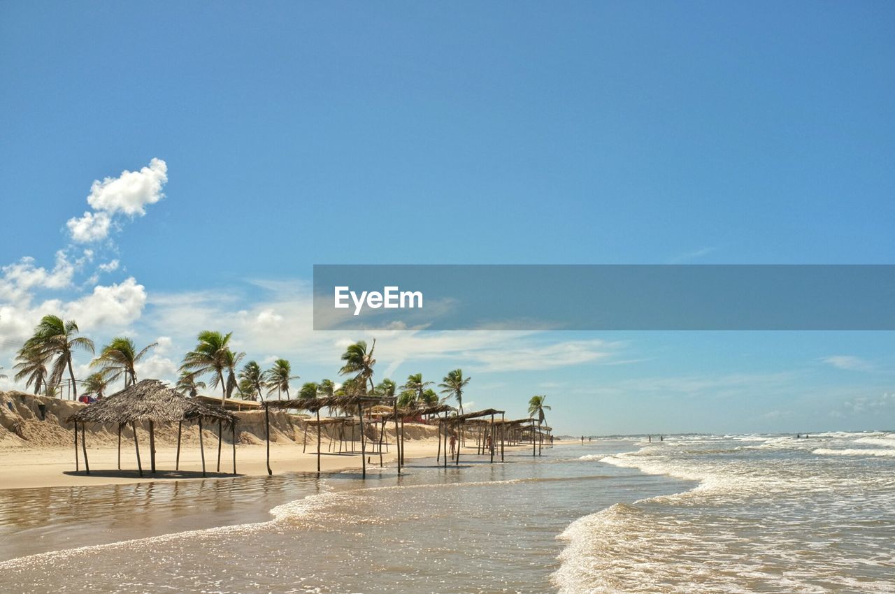 Scenic view of shore and sea against blue sky
