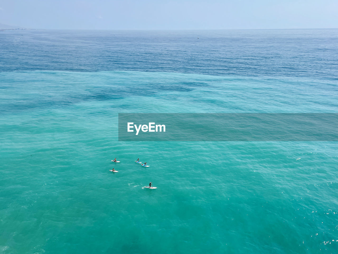 People stand up paddle boarding in the sea