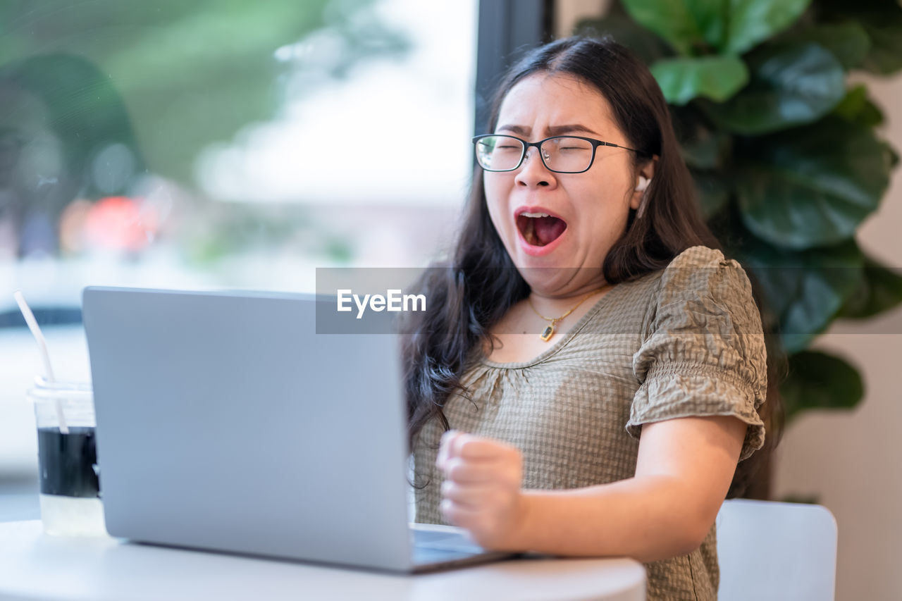 YOUNG WOMAN USING MOBILE PHONE