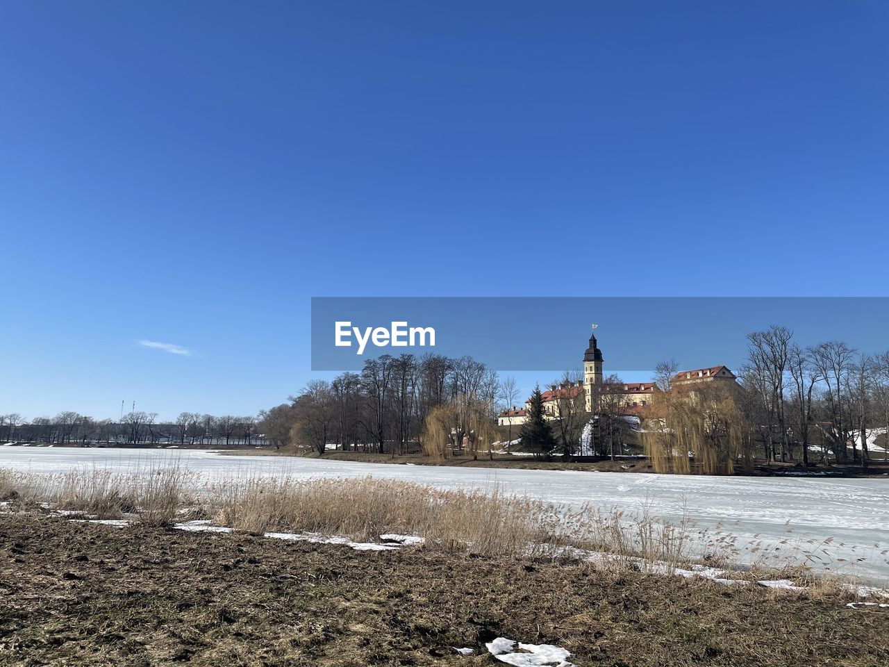 SNOW ON FIELD AGAINST CLEAR BLUE SKY