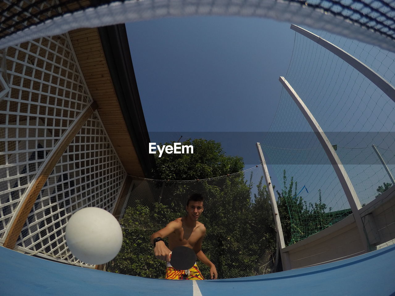 Shirtless man playing table tennis