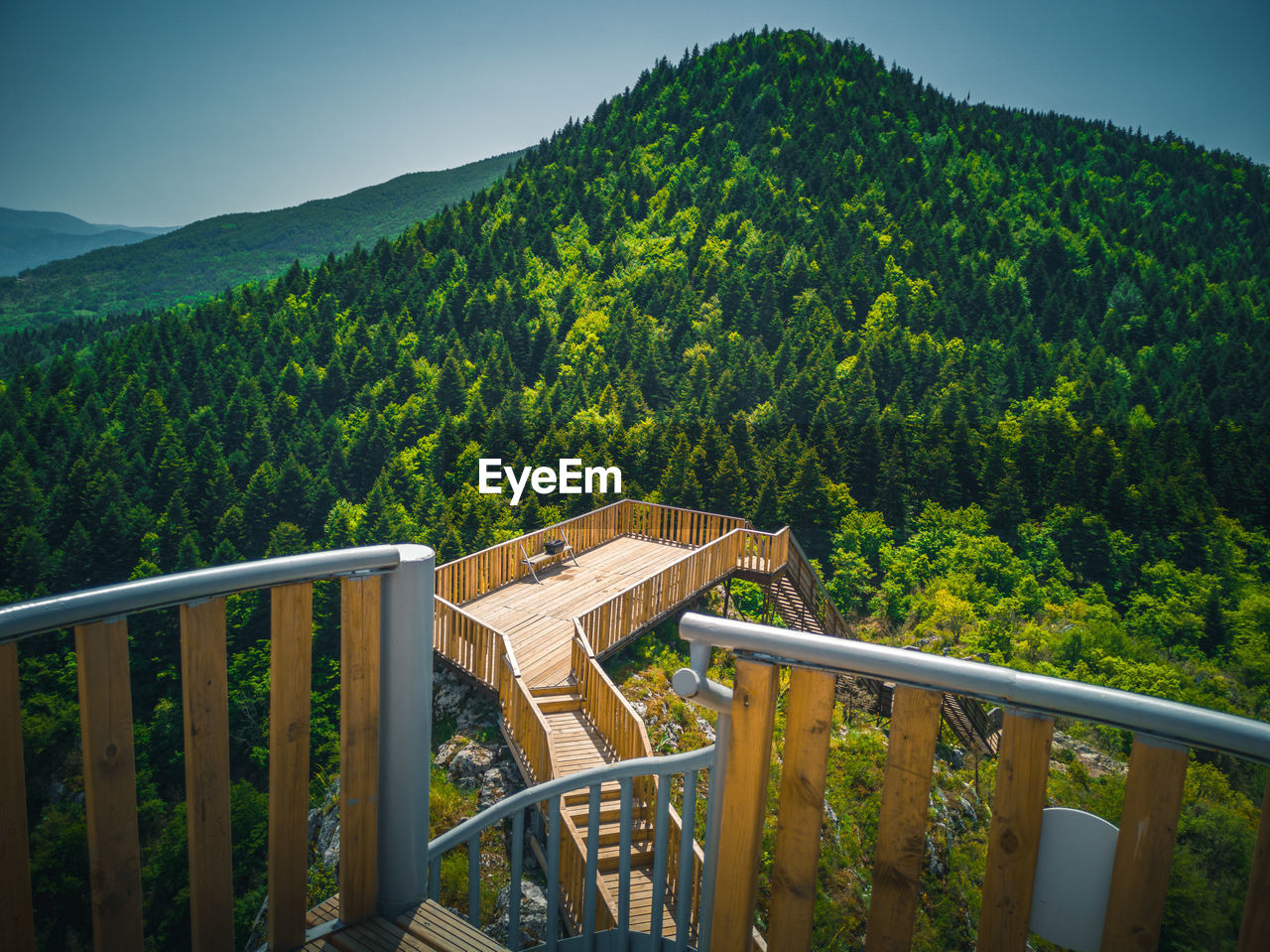 BUILT STRUCTURE IN FOREST AGAINST MOUNTAINS