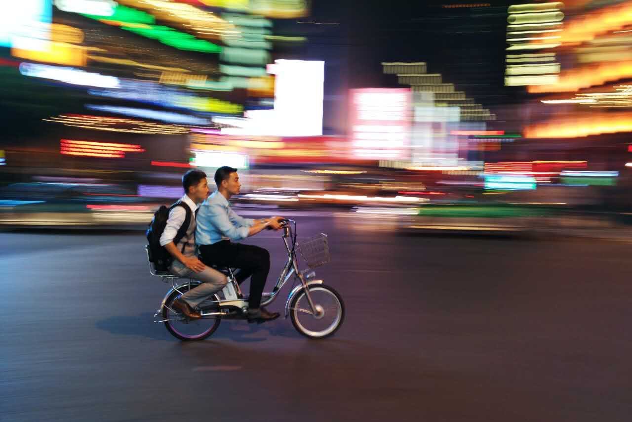 SIDE VIEW OF A MAN RIDING BICYCLE ON ROAD