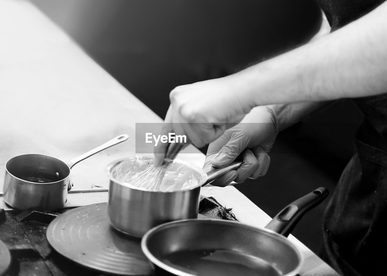 MIDSECTION OF PERSON PREPARING FOOD ON KITCHEN