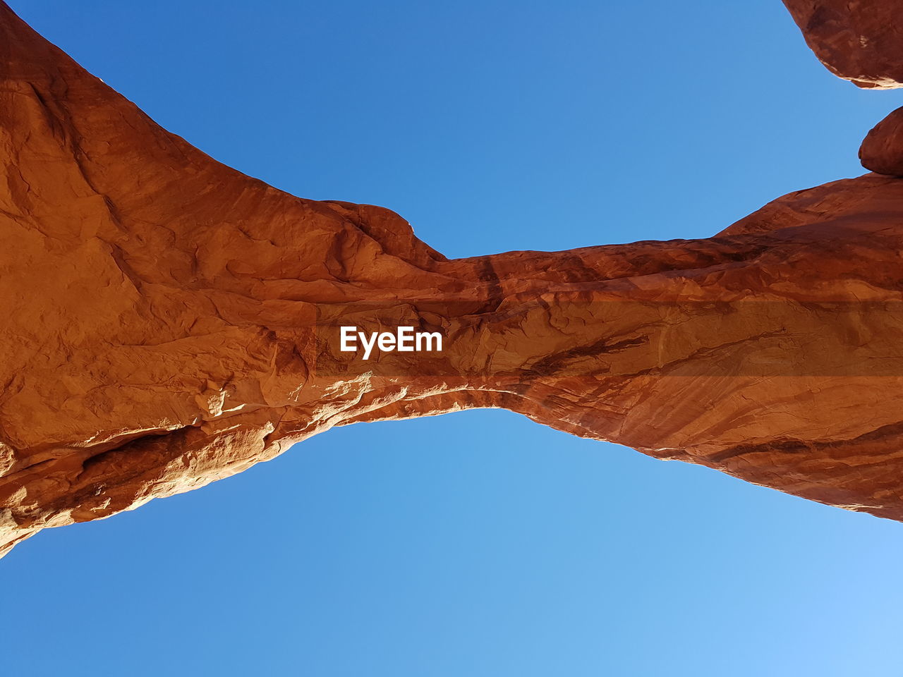 Low angle view of rock formation against clear blue sky